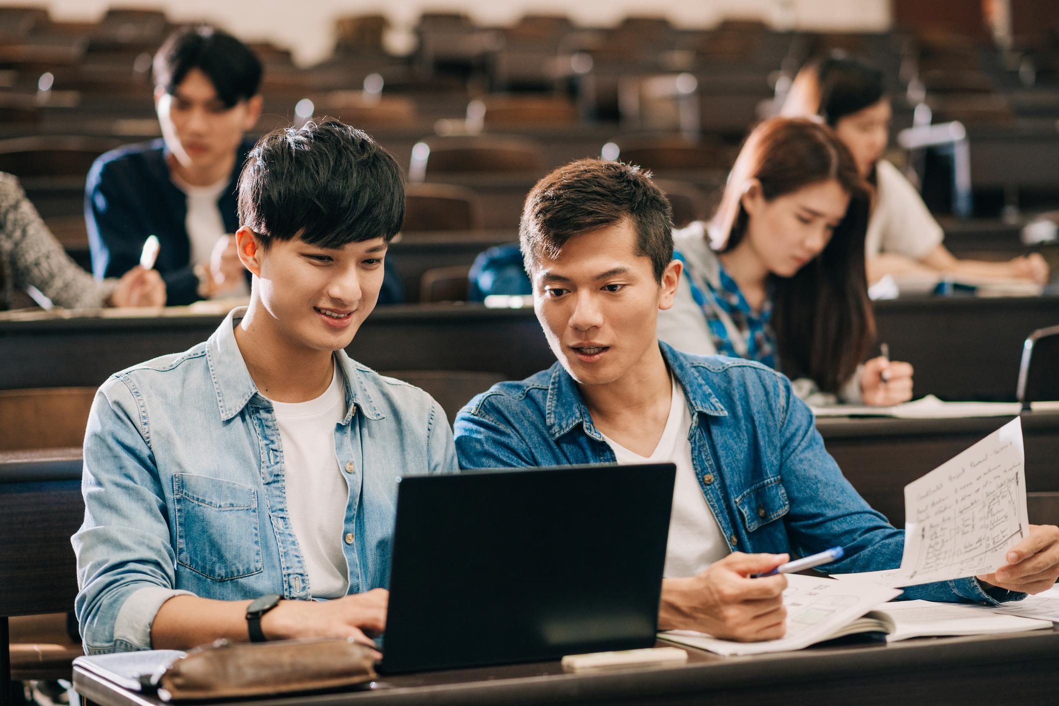 two students looking at a laptop